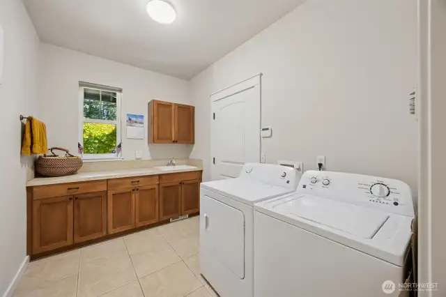 Huge utility room has plenty of storage and includes a utility sink.