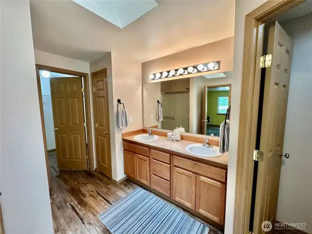 Primary double vanities, toilet room to the right and walk-in closet to the left.