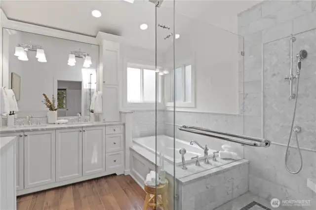 Chic, beautifully finished spa-like bathroom. Huge step in shower, built-in soaking tub, and double vanity with countertop apothecary-style cabinets. Crown molding, gorgeous herringbone pattern wraps around the bathtub and shower walls, plus shampoo niches in the shower and at the tub. Vaulted ceilings and a skylight make this room a wonderful place to escape to.