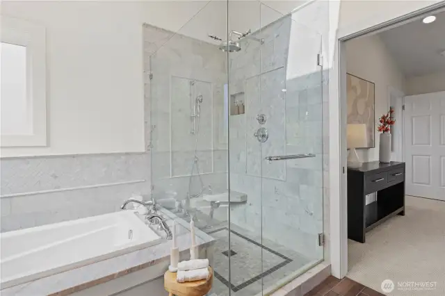 Oversized walk-in shower with accent tile inlay and shampoo niche. Rain shower in addition to a handheld, adjustable shower head.