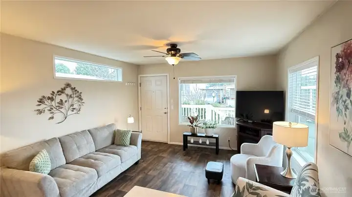 The living room features ample windows for daylighting, high end fan/light and laminate flooring.