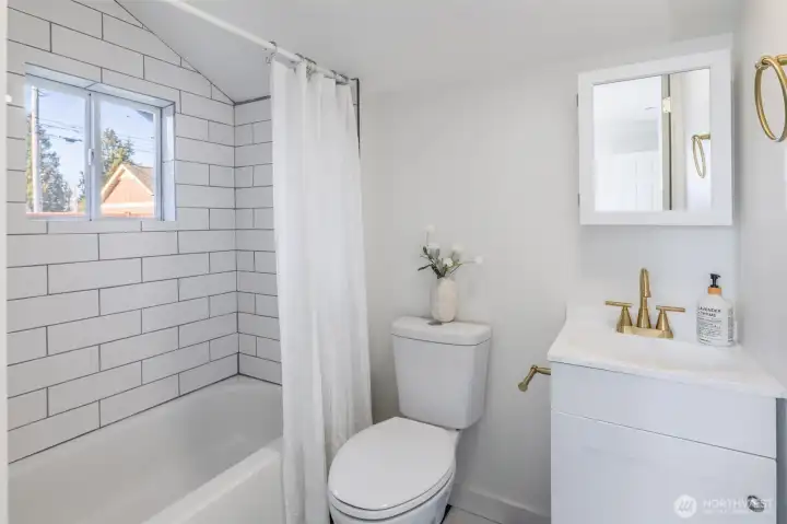 Completely remodeled bathroom featuring new tile shower surround, modern fixtures, and a clean, timeless design.