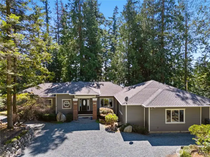 Nestled beneath towering evergreens, this inviting rambler offers peaceful privacy, classic curb appeal, and a serene Northwest setting.