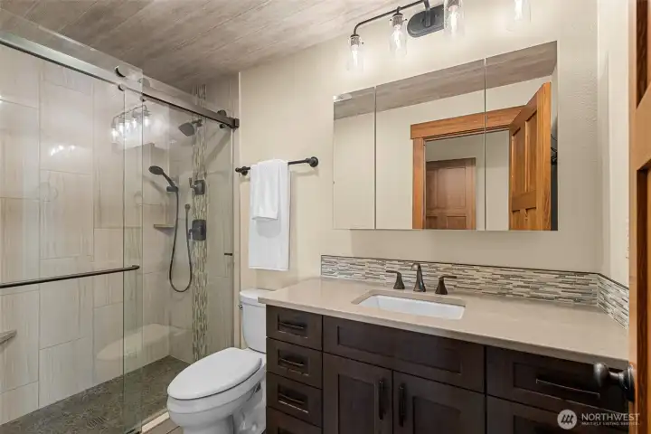 Primary bathroom, tiled shower and upgraded cabinetry and granite counters