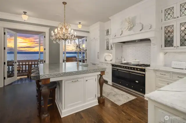 The kitchen, true heart of the home, is a true masterpiece of elegance and function. Wavy glass and custom lead doors were meticulously selected to adorn the room cabinetry made of Dovetail solid wood. Note the antique crystal chandelier above the island, a stunning piece which was taken from a 1909 Dutch Colonial home in West Seattle.