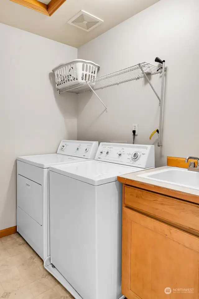 Convenient upstairs utility room with washer, dryer, and utility sink.