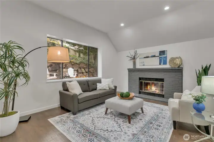 Family room with tall ceilings and wood burning fireplace.