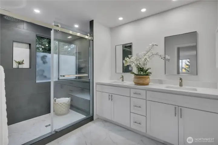 Gorgeous primary bathroom w/double vanity, quartz counters & walk-in frameless glass shower. (water closet is opposite the shower)