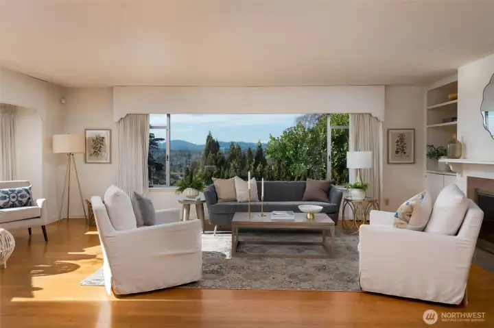 The living room is welcoming and large.  Anchored by wood burning fireplace hearth, the windows look south and west towards the Olympic Mountain range & downtown Bremerton.