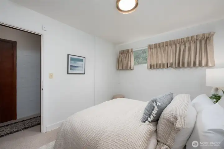 Lower level bedroom with door to hall, close to exterior entrance.