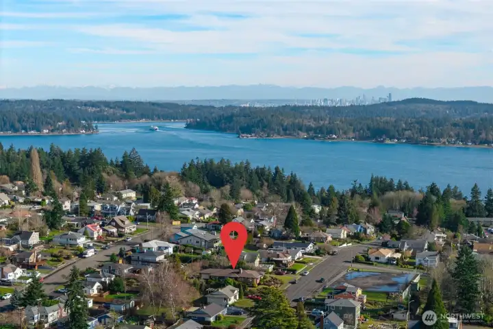 View east through Rich Passage, southern tip of Bainbridge Is and Port Orchard.  City of Seattle skyline in distance.  Passenger & car ferries leave multiple times a day from Bremerton to Seattle.