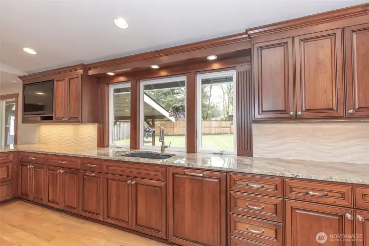 View from the kitchen window highlights the backyard, offering a peaceful setting often visited by hummingbirds.