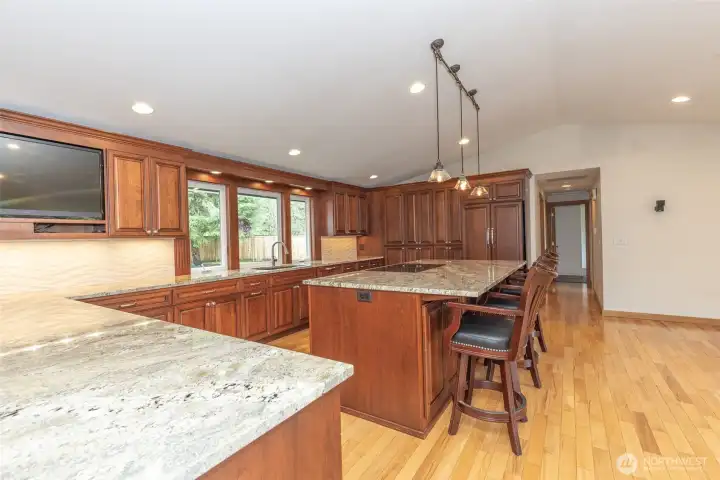 Kitchen is a central feature of the home’s layout, offering abundant counter space and ample storage. Refrigerator and dishwasher feature matching cabinet fronts for a seamless look. Recessed lighting and a built-in TV enhance functionality, and bar stools are included with the home.