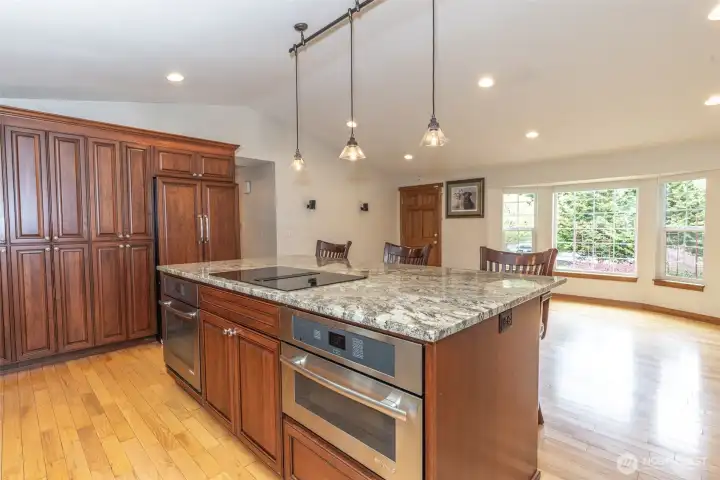 Center island features a cooktop with built-in microwave and oven, offering a functional layout with added prep space and convenience.