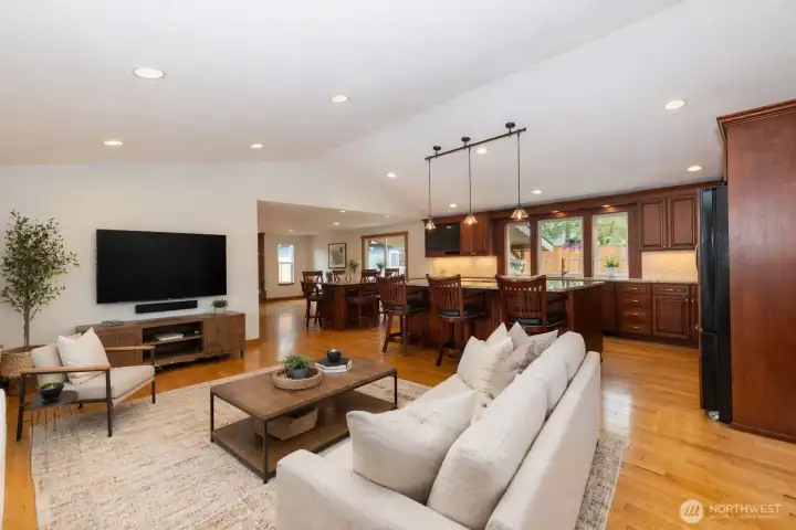 "Virtually Stage" Bright, open living area with beautiful hardwood floors and expansive bay style windows that fill the space with natural light. Seamlessly connected to the kitchen, this inviting layout features a spacious seating area, modern recessed lighting, perfect for everyday living and entertaining.