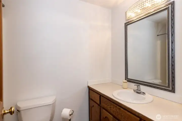 Full bath located on Left in hallway, featuring a tub/shower combination, vanity with storage, and bright lighting.