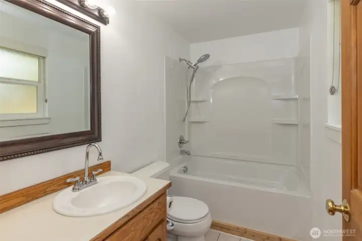 Full bathroom off the primary bedroom featuring a tub/shower combination, vanity with storage, and bright lighting.