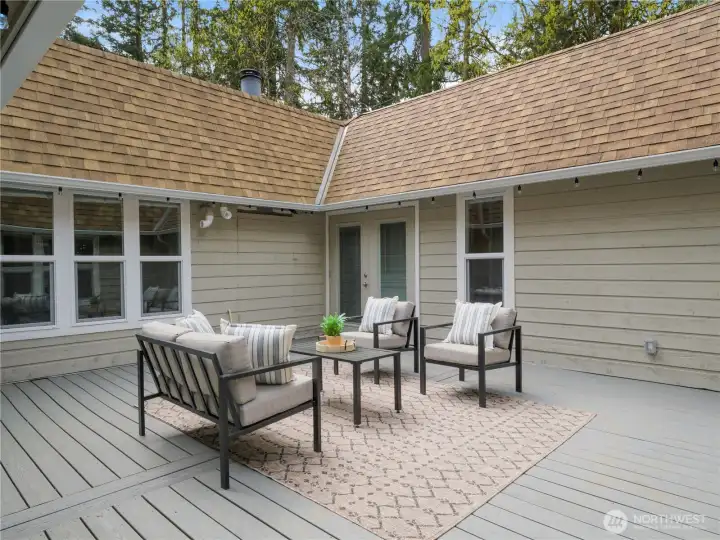 A stunning central atrium with Trex decking. The French doors in the background lead right to the primary bedroom and guest wing, so access is easy and convenient.