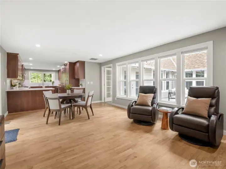 Open family room with original hardwood floors (painstakingly restored), recessed lighting, and access to the outdoor space.