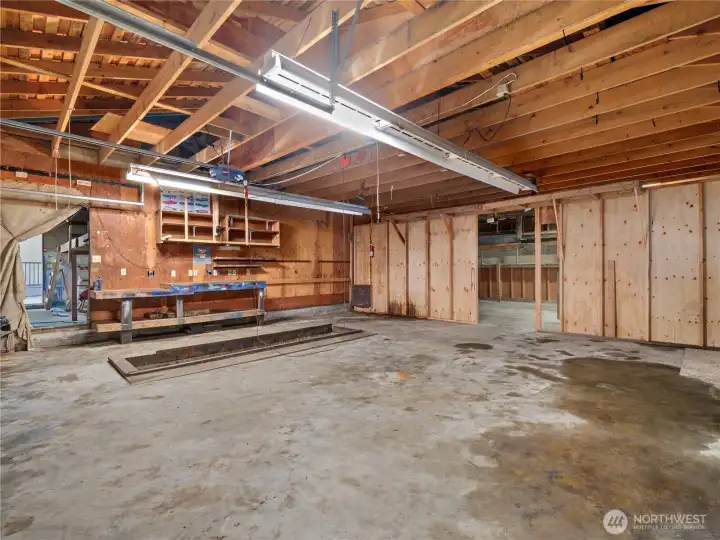 The garage features 3 separate entrances, which are currently separated by faux walls that could easily be removed. Here, you can see the mechanics pit and the wall that once housed a full bay of tools and equipment. The possibilities here are endless. In the background is the double-deep left side garage when you're facing the house. This section is accessed from the back driveway.