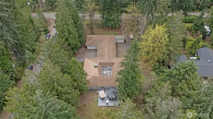 Private setting surrounded by mature trees, showcasing the home’s unique footprint and spacious lot.