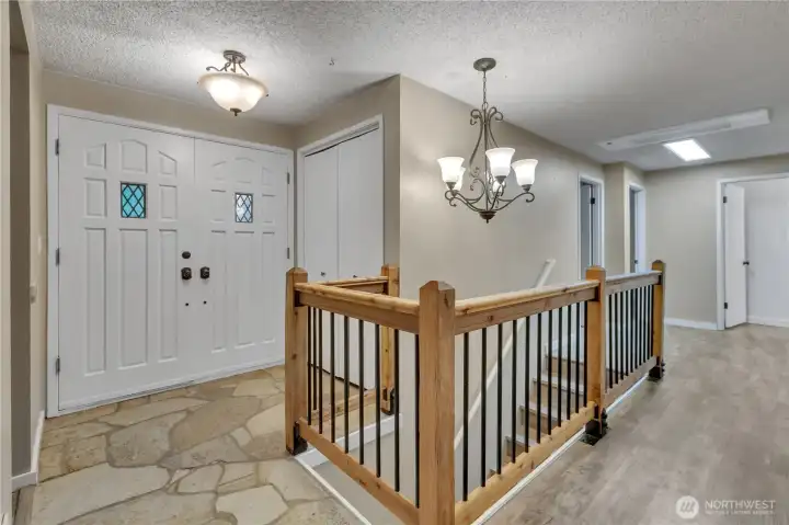 Lodge style staircase off of entry leads to the full basement. Stone entryway and lovely double door entry with coat closet are visible. Lodge style staircase off of entry leads to the full basement. Stone entryway and lovely double door entry with coat closet are visible.