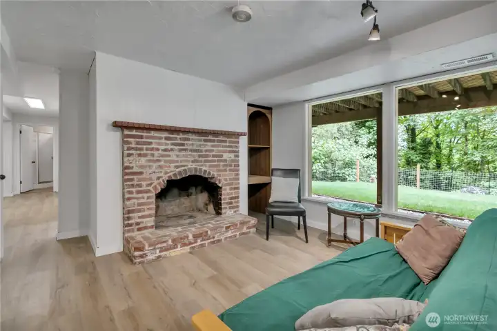 Another view of the brick fireplace. The hall leads down to a 3/4 bathroom and extra rooms and office. Another view of the brick fireplace. The hall leads down to a 3/4 bathroom and extra rooms and office.