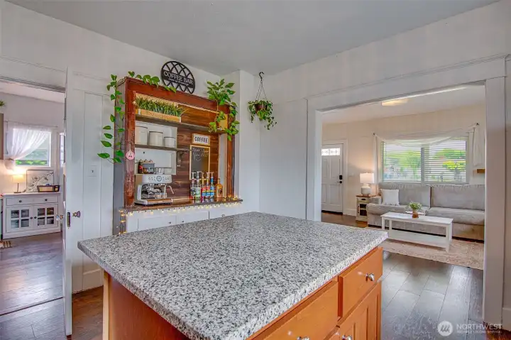 The kitchen features a slab granite island with eating space and extra storage, creating a functional and welcoming gathering area.