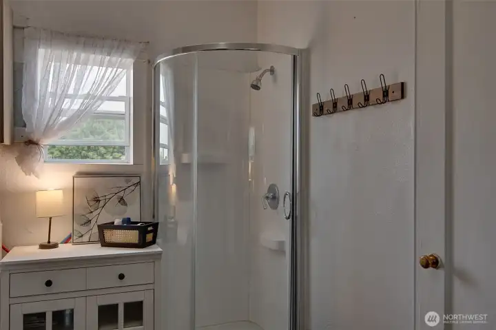 A window in the downstairs bath brings in natural light, making the space feel brighter and more inviting.