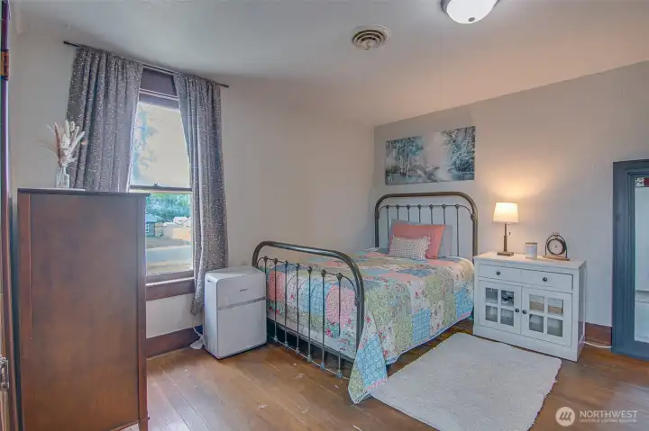 Original hardwood floors in the bedroom bring warmth, charm, and authentic 1918 character to this thoughtfully updated home.