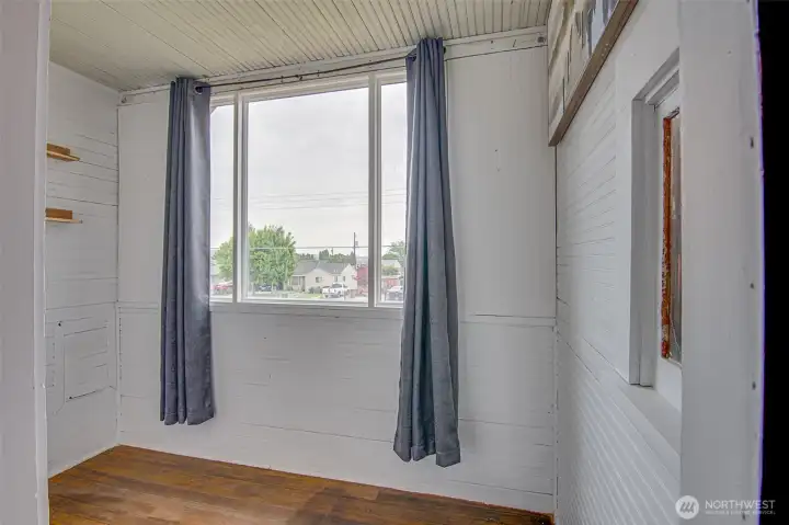Flexible sitting room with wainscoting, a huge window, and potential use as an extra bedroom