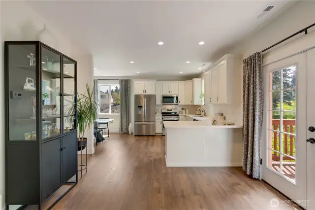 Open kitchen with breakfast nook and French doors to the deck.
