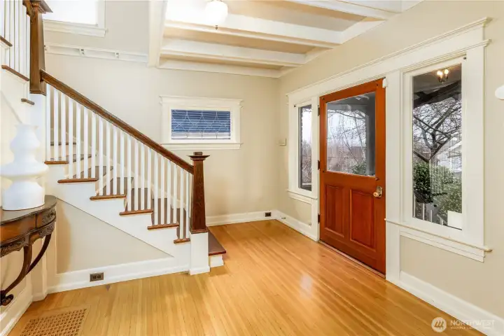 Formal entry way with beautiful hardwood floors and stately staircase with original wood banister.
