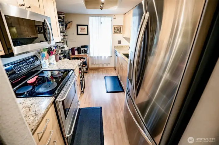 Eating area and sliding door to deck on far side. Countertops are a waterproof designed shone material. Laminate plank flooring.