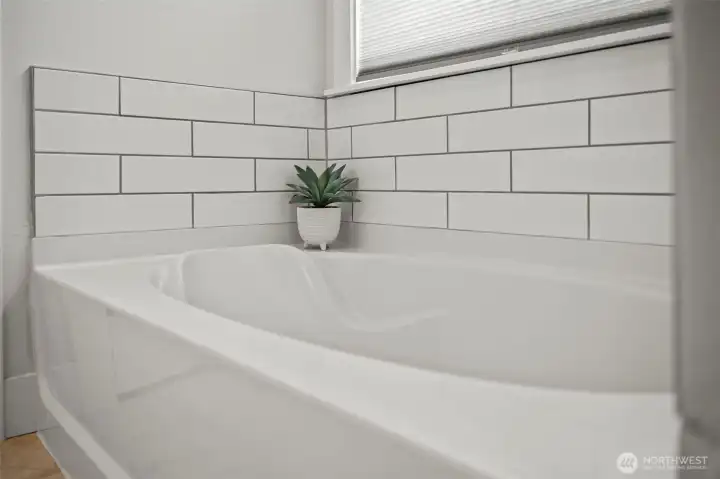 Garden tub with tile surround is inviting with loads of natural light