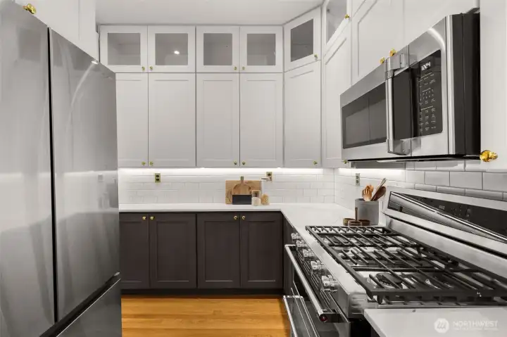 In the kitchen, you’ll find white quartz countertops, push-button replica light switches, tile backsplashes, gas range, & all high-end appliances.