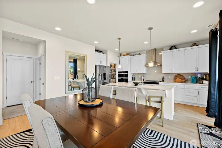 Open floor plan means everyone's in view from the kitchen, dining and family room. Door to garage and guest bath left of frame.