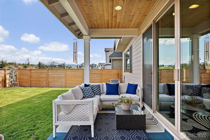 Another view of the covered porch and fenced level back yard.