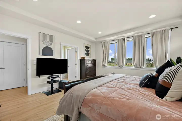 Primary bedroom with upgraded LVP flooring, plenty of room for your king bed and furniture and 2 walk-in closets