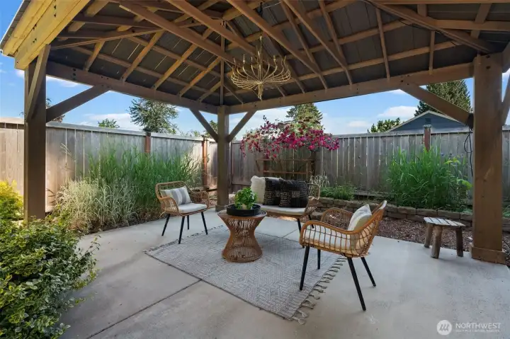 Outdoor living at its finest! Relax under the stylish pergola on this low-maintenance concrete patio, the perfect setting for sunny afternoons and warm evenings.