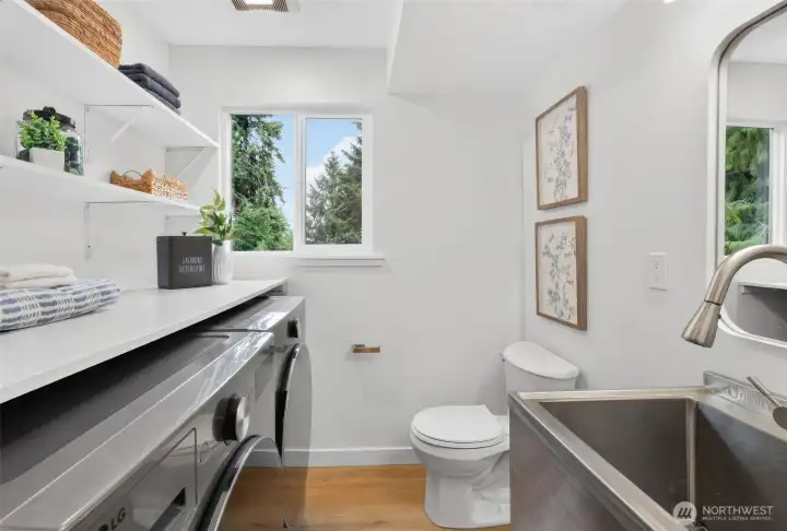 A hardworking little hub with LG front-load washer and dryer, a convenient half bath, and a stainless steel utility sink—practical, polished, and ready for real life.