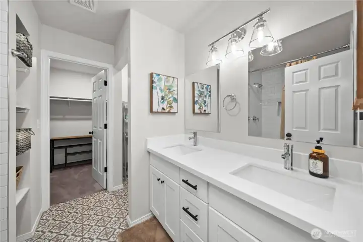 Primary suite bath with a walk in shower and closet.