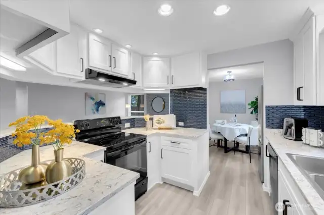 Refreshed Kitchen with quartz counters, tile backsplash, and white shaker cabinets.