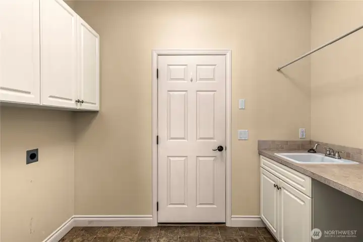 Laundry sapcee with large sing and door to garage.