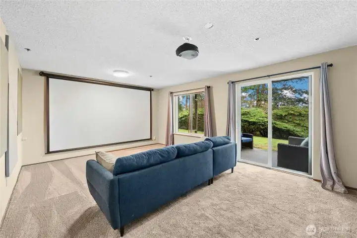 Downstairs family room with full-screen projector unit-stays with home.  Access to shared backyard.