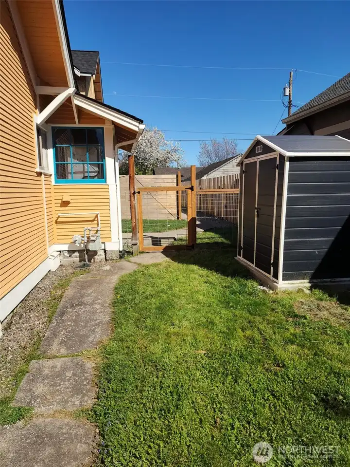 Yard with gate to back and garden shed.