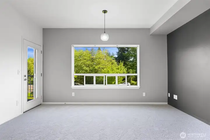 Large picture window in living room overlooking the pond, entrance to balcony on left side