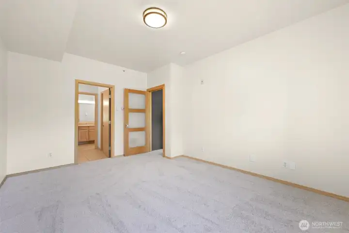 Primary bedroom #1, door to the right leads to the living room, left is private en suite bathroom and walk-in closet.