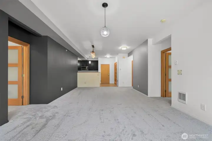 View from living room towards kitchen, primary #1 on the left, primary #2 on the right. Note beautiful upgraded hemlock doors and updated lighting