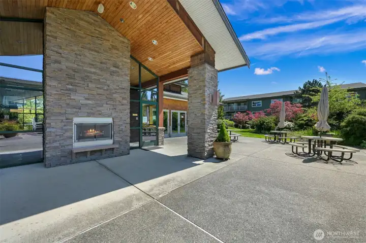 Outdoor clubhouse patio complete with picnic tables and outdoor fireplace
